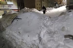 Жители Щёкино проложили дорожку по заваленной снегом машине.